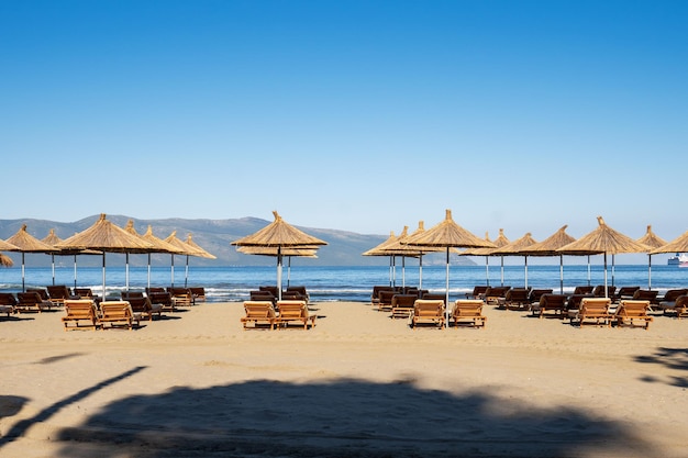 Parasols de plage du soleil et chaises longues sur la plage