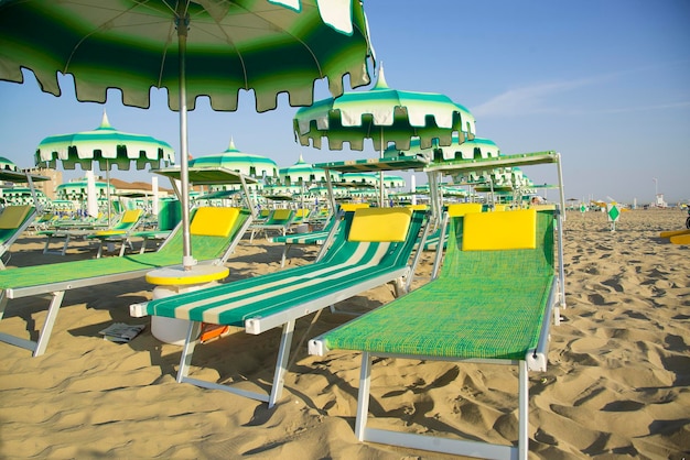 Parasols verts et chaises longues sur la plage de Rimini en Italie