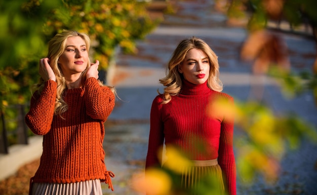 Parc d'automne Tendance plissée filles en jupe ondulée et pull beauté féminine vraie féminité automne femmes en plein air amies marcher dans le parc journée ensoleillée avec des feuilles mortes saison de la mode d'automne