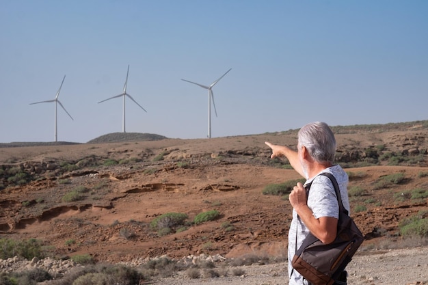 Parc éolien à énergie alternative sur la montagne Vue arrière d'un homme mûr regardant une ferme d'éoliennes