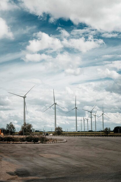 Parc éolien avec espace copie sur asphalte et ciel nuageux bleu