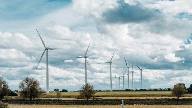 Parc éolien situé sur plaine avec fond de ciel nuageux