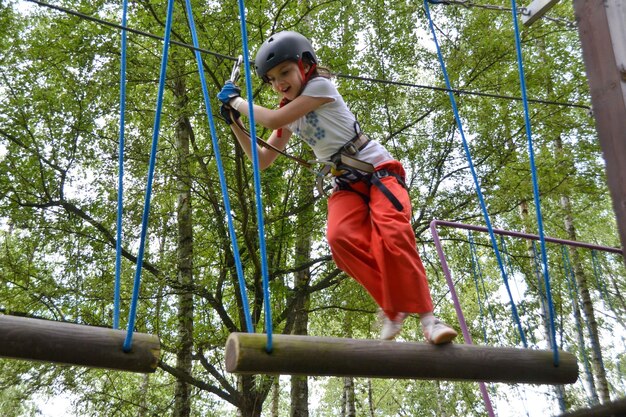 Parc d'escalade d'aventure - les gens sur le parcours avec casque de montagne et équipement de sécurité