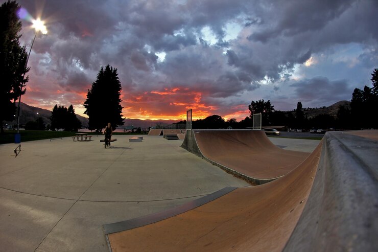 Photo parc de planche à roulettes avec rampe de sport contre un ciel nuageux au coucher du soleil
