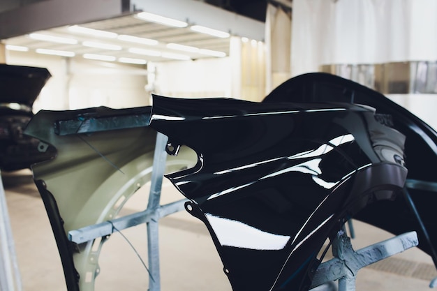 Le pare-chocs de la voiture est prêt à être peint à l'atelier de carrosserie.