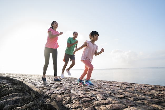 Parent asiatique et enfants faisant du sport en plein air