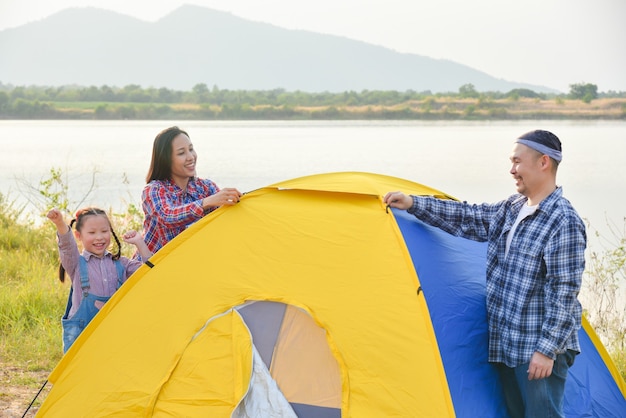 Photo parent asiatique avec tente de fille au bord du lac. aventure d'activités de plein air en famille en vacances.