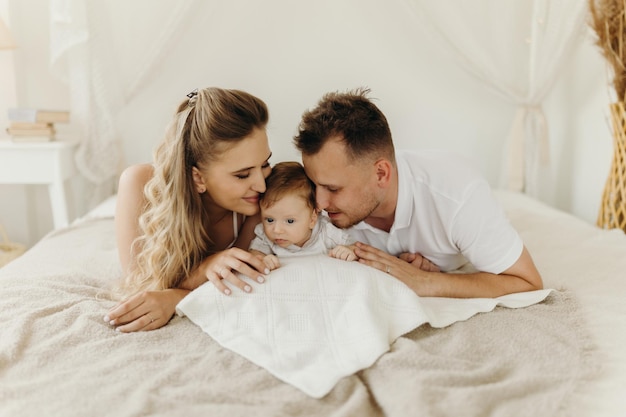 Parent et bébé famille heureuse s'amusant au lit portrait famille heureuse