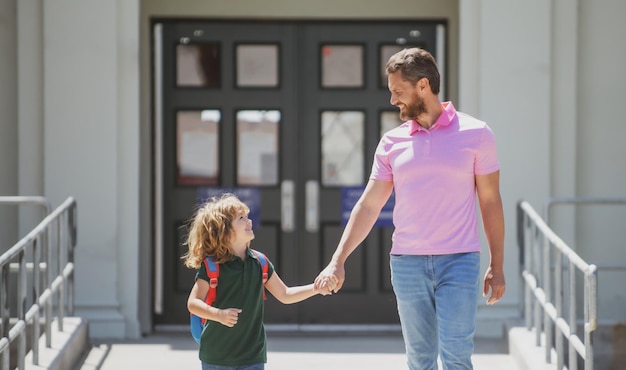 Parent emmenant l'enfant à l'école Élève de l'école primaire aller étudier avec sac à dos à l'extérieur Père et fils courent avec le père après son retour de l'école Éducation familiale à l'école et concept de plein air