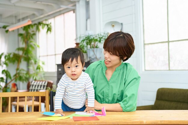 Parent et enfant jouant à l'origami à l'intérieur