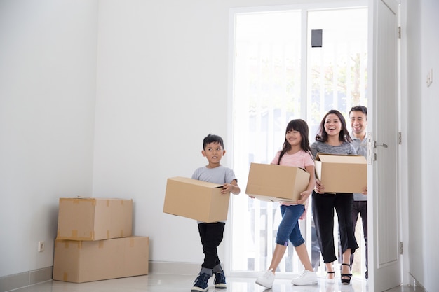 Parent et enfants avec boîte en carton. emménager dans une nouvelle maison