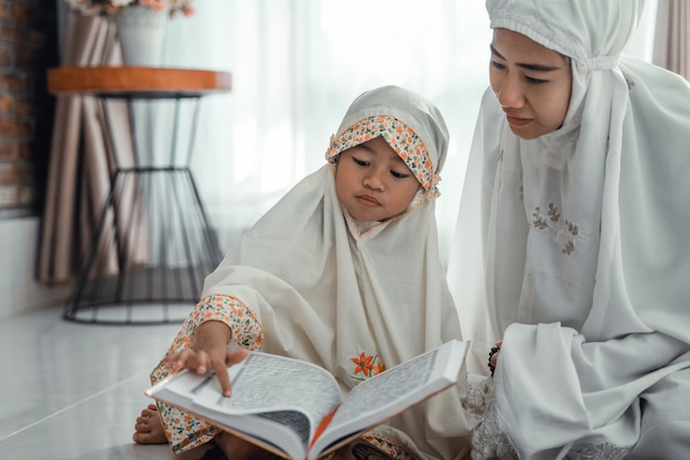 Parent et fille musulmane lisant le coran