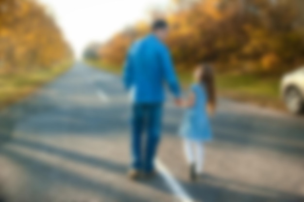 Un parent heureux avec enfant marchent le long de la route dans le parc lors d'un voyage dans la nature