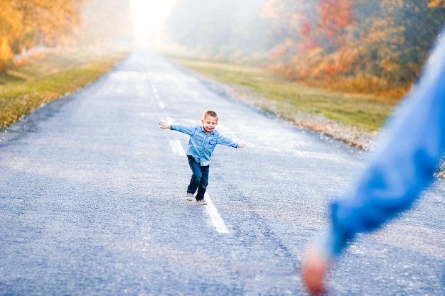 Photo un parent heureux avec enfant marchent le long de la route dans le parc lors d'un voyage dans la nature