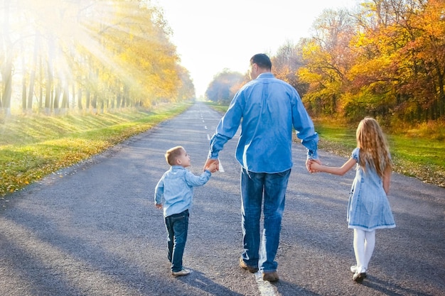 Un parent heureux avec enfant marchent le long de la route dans le parc lors d'un voyage dans la nature