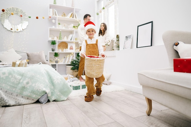 Parent et leur petit fils s'amusant et jouant ensemble à l'intérieur au moment de Noël