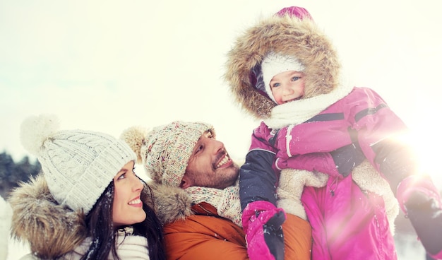 Photo parentalité, mode, saison et concept de personnes - famille heureuse avec enfant en vêtements d'hiver à l'extérieur