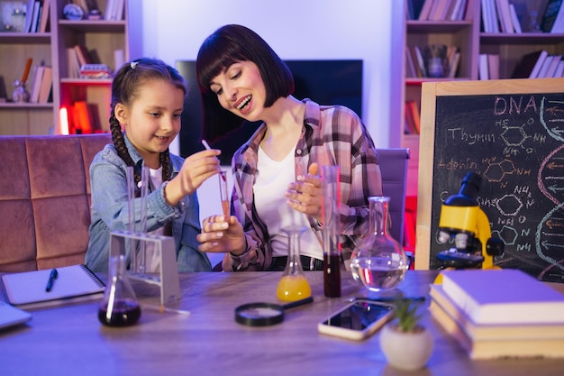 Photo parente mère avec fille enfant faisant un test chimique le soir