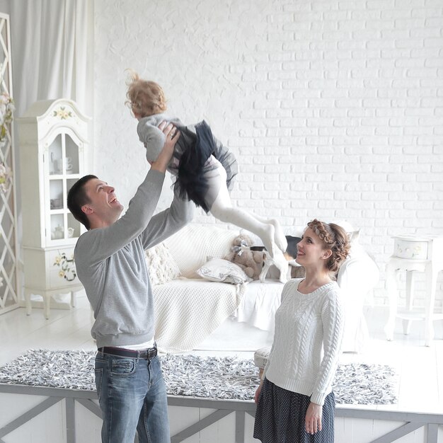 Des parents aimants jouent avec leur fille dans la chambre.photo avec place pour le texte