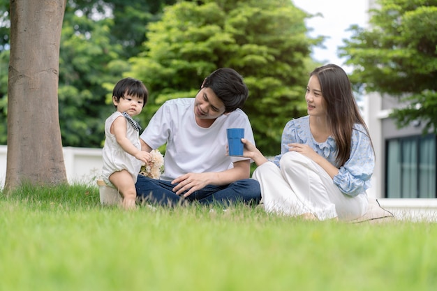 Parents asiatiques et un enfant jouant dans le jardin à la maison. Notion de famille.