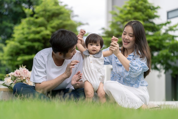 Photo parents asiatiques et un enfant jouant dans le jardin à la maison. notion de famille.