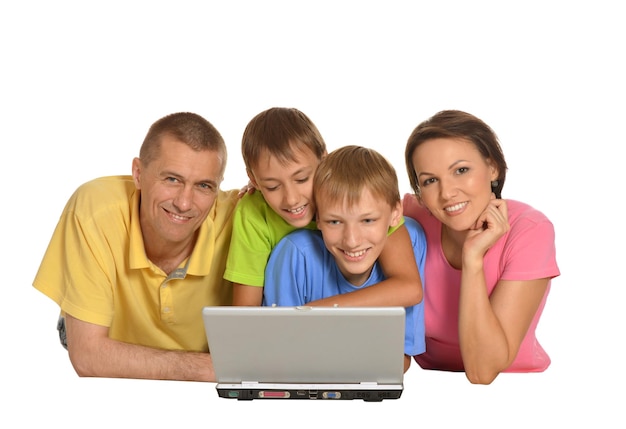 Parents avec deux fils à l'aide d'un ordinateur portable moderne isolé sur fond blanc