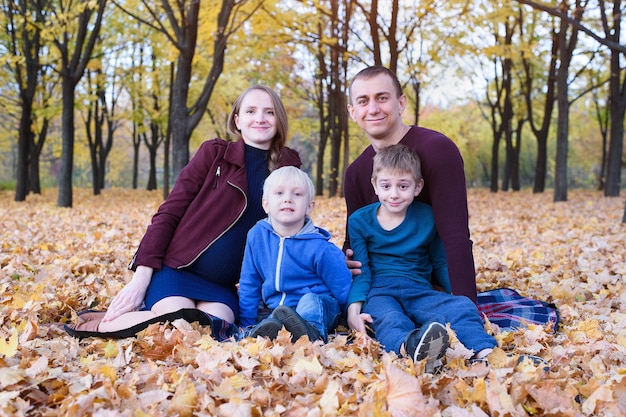 Les parents et deux fils se détendent et discutent dans le parc