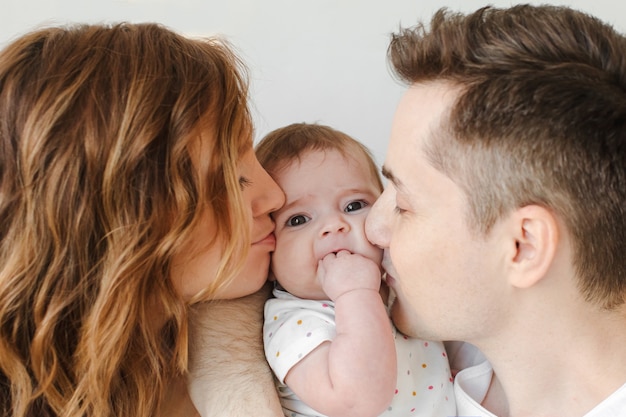 Parents embrassant bébé dans les joues