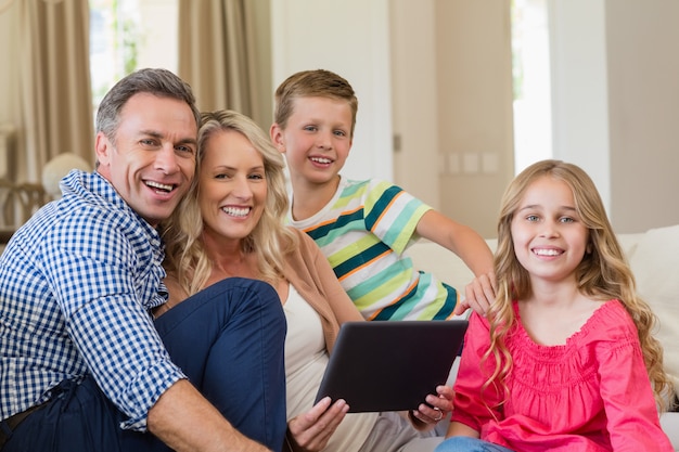 Parents et enfants à l'aide d'une tablette numérique dans le salon