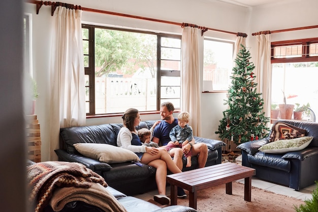 Photo parents et enfants assis sur le canapé à la maison