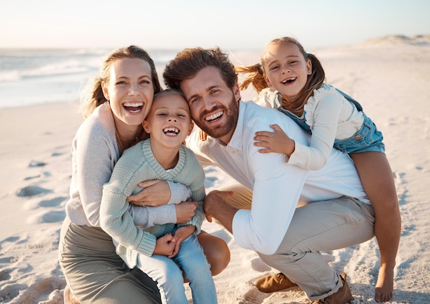 Parents enfants et câlins à la plage portrait et sourire pour l'amour excité ou de liaison en vacances en été Père mère et fille enfants sur le sol rire ou de connexion au soleil par l'océan en Espagne