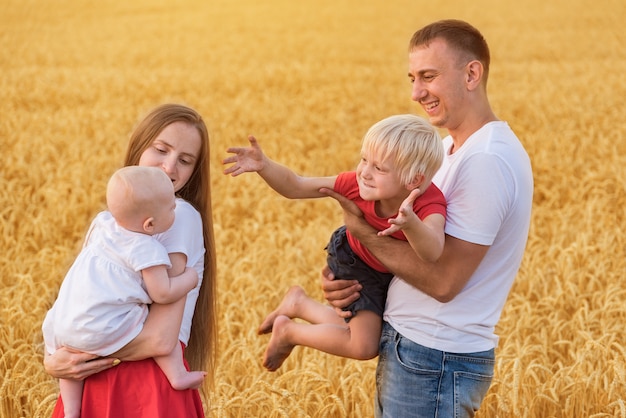 Parents et enfants debout sur un champ de blé