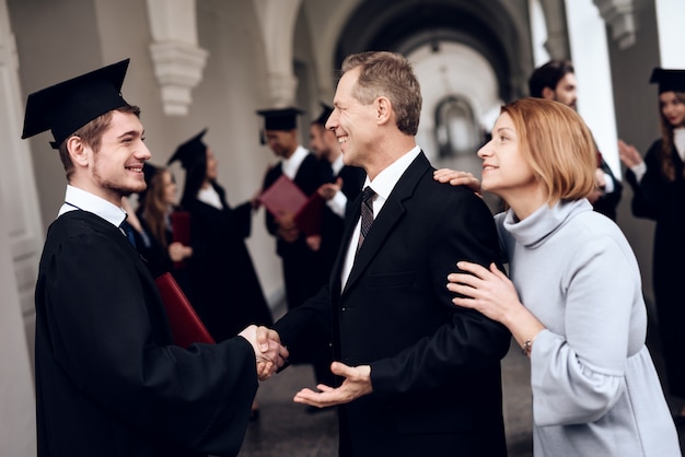 Les parents félicitent l'étudiant qui termine ses études