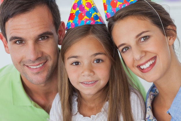 Parents et fille portant un chapeau de fête