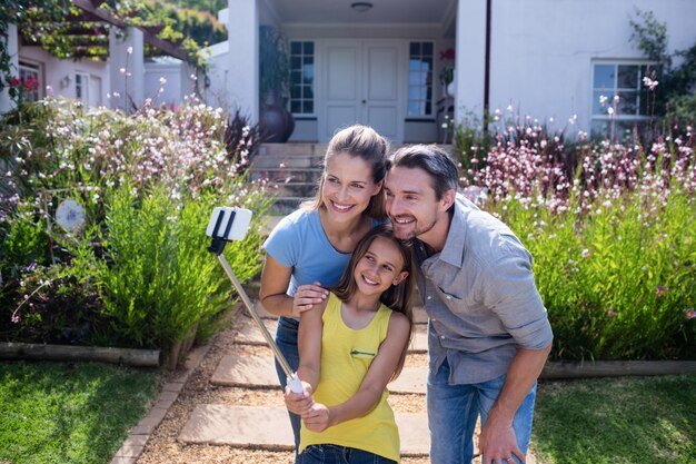 Parents et fille prenant un selfie avec un bâton de selfie