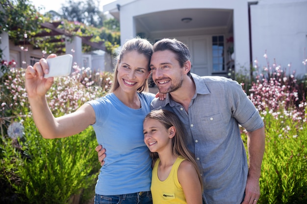 Parents et fille prenant un selfie sur téléphone mobile