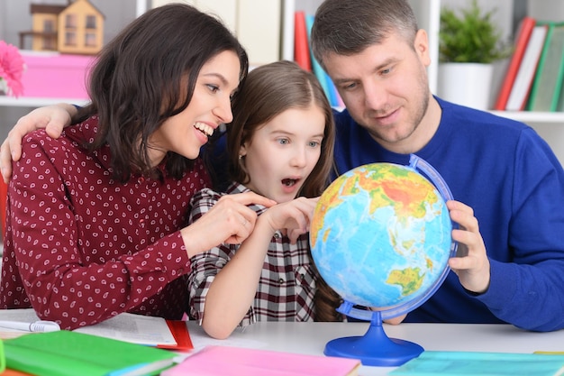 Parents et fille regardant le globe