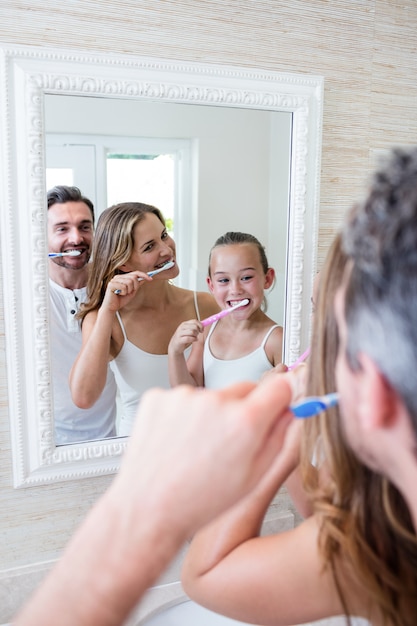 Parents et fille se brosser les dents dans la salle de bain