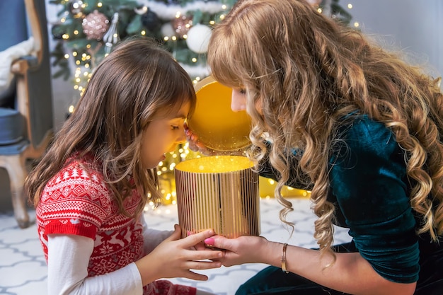 Les parents des filles donnent des cadeaux pour Noël. Mise au point sélective. Vacance.