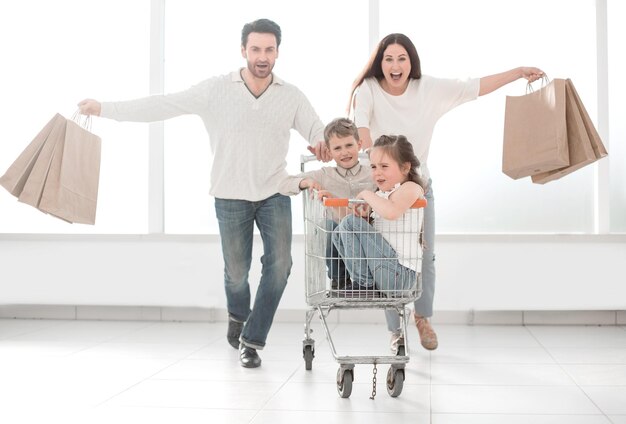 Des parents heureux avec des enfants vont faire du shopping