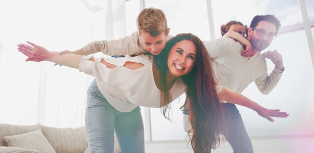 Des parents heureux jouent avec leurs enfants dans le spacieux salon photo avec espace de copie