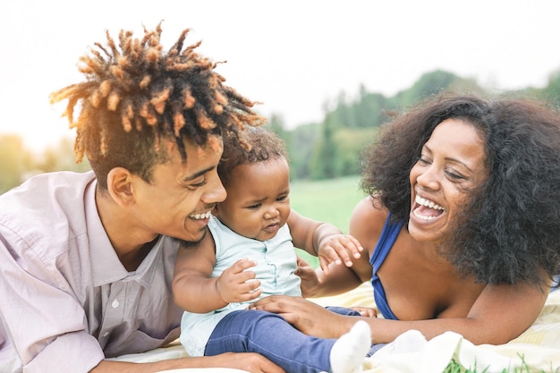 Des parents heureux regardant leur jolie fille contre le ciel.