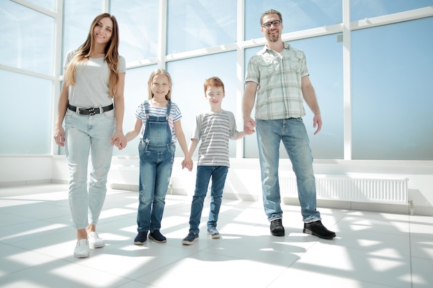 Parents avec de jeunes enfants debout dans la nouvelle photo de la maison avec espace de copie