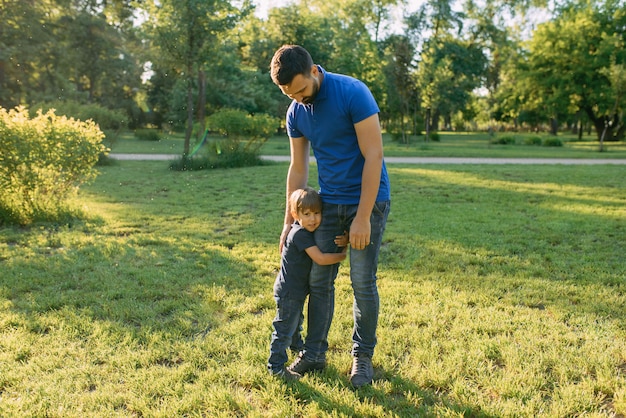 Les parents jouent dans le parc avec leur fils