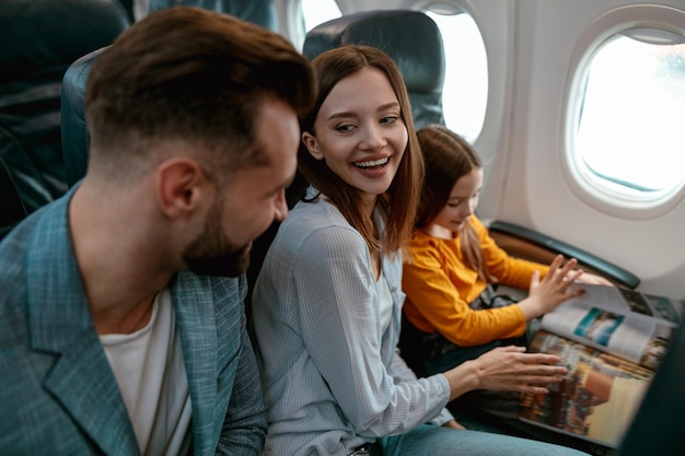 Parents joyeux voyageant avec leur fille en avion