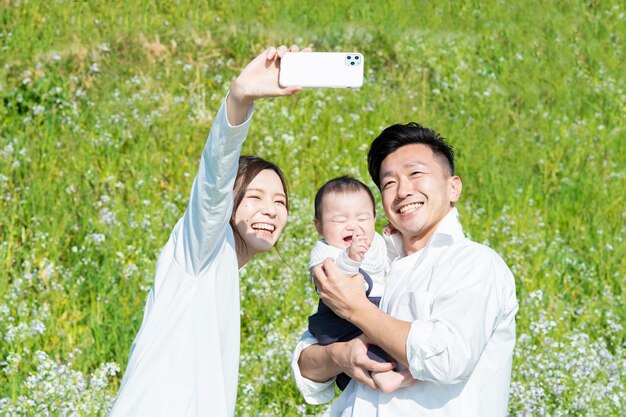 Les parents et leur bébé prennent une photo commémorative à l'extérieur