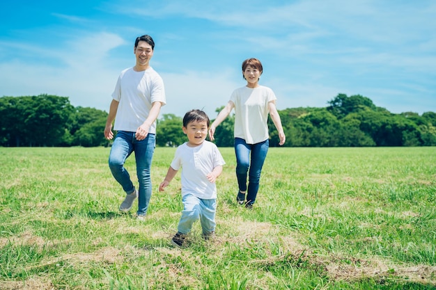 Parents Et Leur Enfant Courant Autour Du Pré