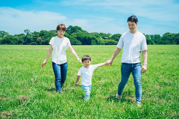 Parents et leur enfant courant autour du pré