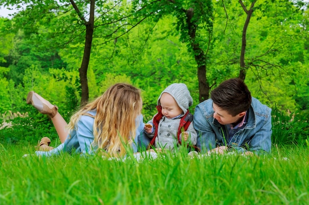 Les parents avec leur fils jouent sur la pelouse du parc