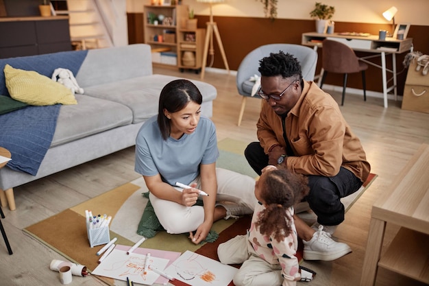 Photo des parents avec leur petite fille dans le salon.